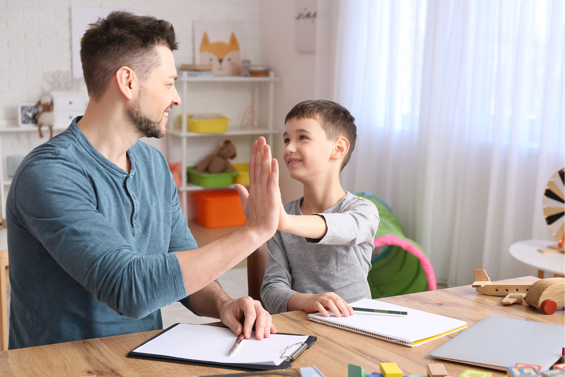 Male-psychologist-working-with-little-boy-in-office.-Autism-concept